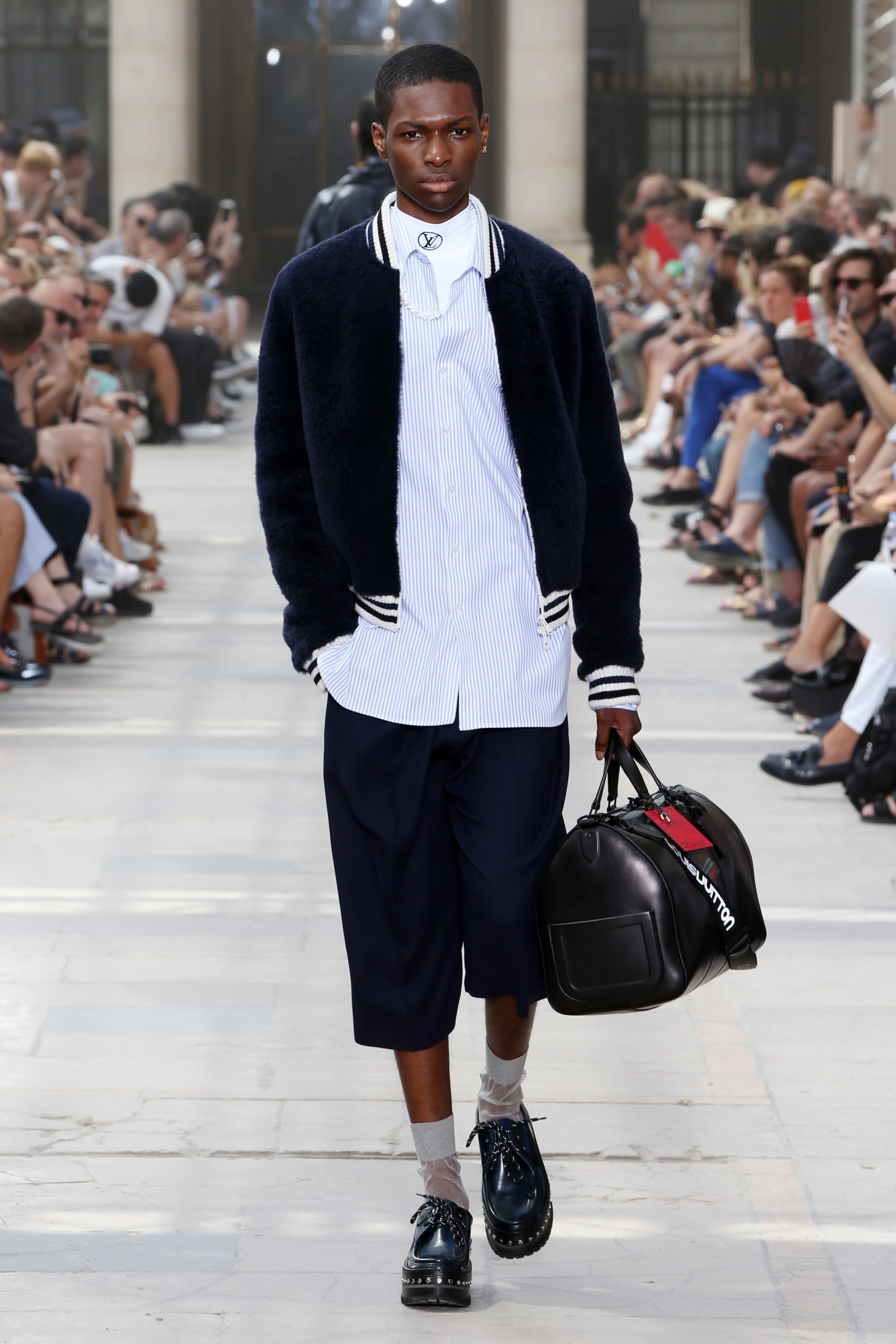 Man with Louis Vuitton Bag and Fila White Sneakers before Daks